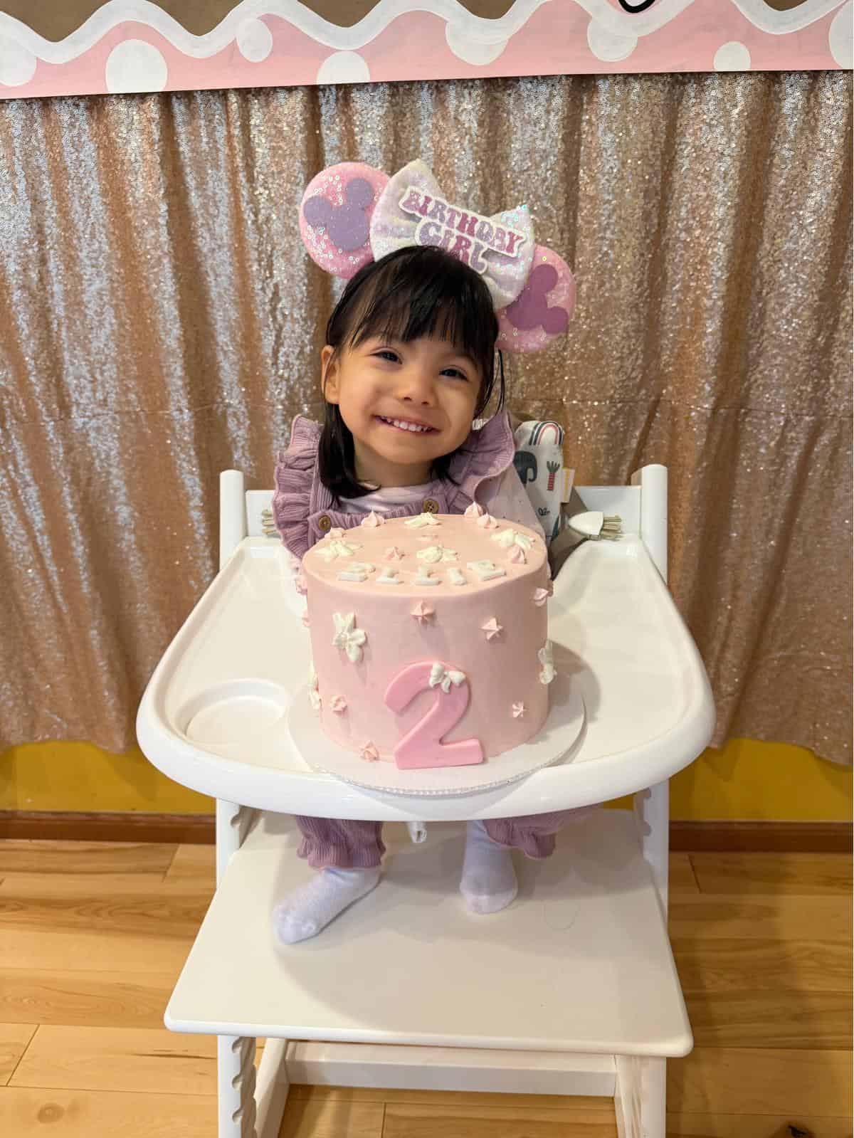 Ellie Guay smiling with her birthday cake in front of her