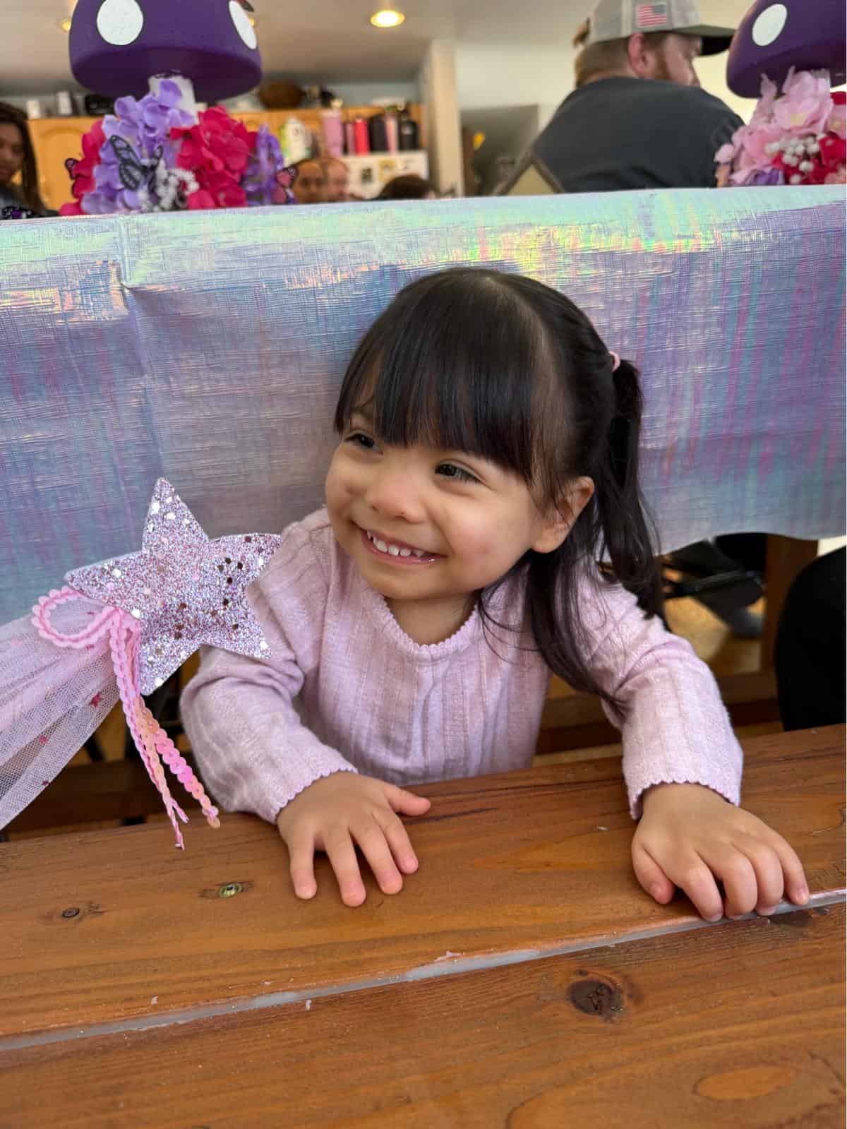 A smiling Ellie Guay leaning forward on a table