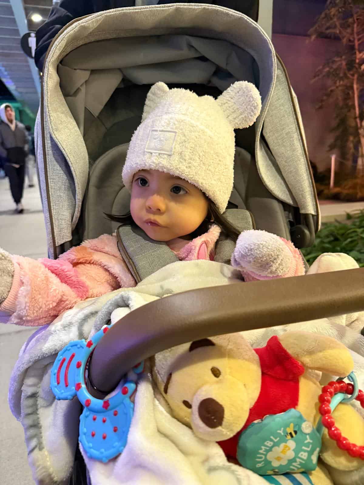 Ellie Guay wearing a sweater cap while riding in a stroller